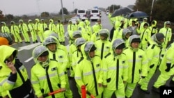 Police officers stand guard to block trucks containing anti-North Korea leaflets on a road in Paju near demilitarized zone, South Korea, October 22, 2012. 