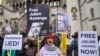Demonstrators hold banners outside the Royal Courts of Justice in London, Feb. 20, 2024. Lawyers for WikiLeaks founder Julian Assange made his final appeal against his impending extradition to the United States at the court.