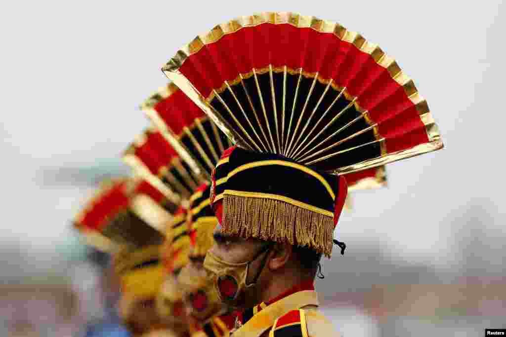 Police personnel wearing face masks take part in a full-dress rehearsal for India's Independence Day celebrations at the historic Red Fort in Delhi, India.