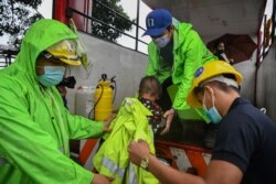 Rescue workers evacuate people living along coastal areas in Manila, Nov. 1, 2020, as Super Typhoon Goni moved towards the Philippine capital.