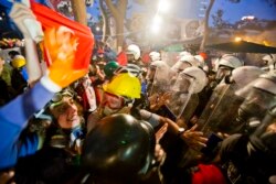 FILE - Protesters try to resist the advance of riot police in Gezi Park in Istanbul, Turkey, June 15, 2013.