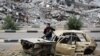 A Palestinian child stands inside a damaged car in front of a destroyed building in the war-devastated Bureij refugee camp in the central Gaza Strip, Feb. 7, 2025. 