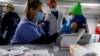 FILE - A Tyson Foods team member receives a COVID-19 vaccine from health officials at the Joslin, Illinois facility, Feb. 19, 2021. 
