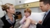 FILE - Ami-Louise Cochrane, center, receives a flu vaccination at Flinders Medical Center, in Adelaide, Australia. 