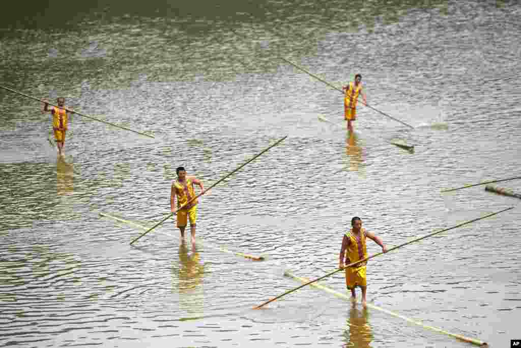 Para peserta mendayung bambu menjelang Festival Perahu Naga di Tanghe, Chongqing, China.