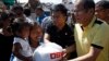 Philippine President Benigno Aquino (R) distributes disaster relief items to survivors of Typhoon Haiyan during his visit to Palo, Leyte province, central Philippines Nov. 18, 2013. 