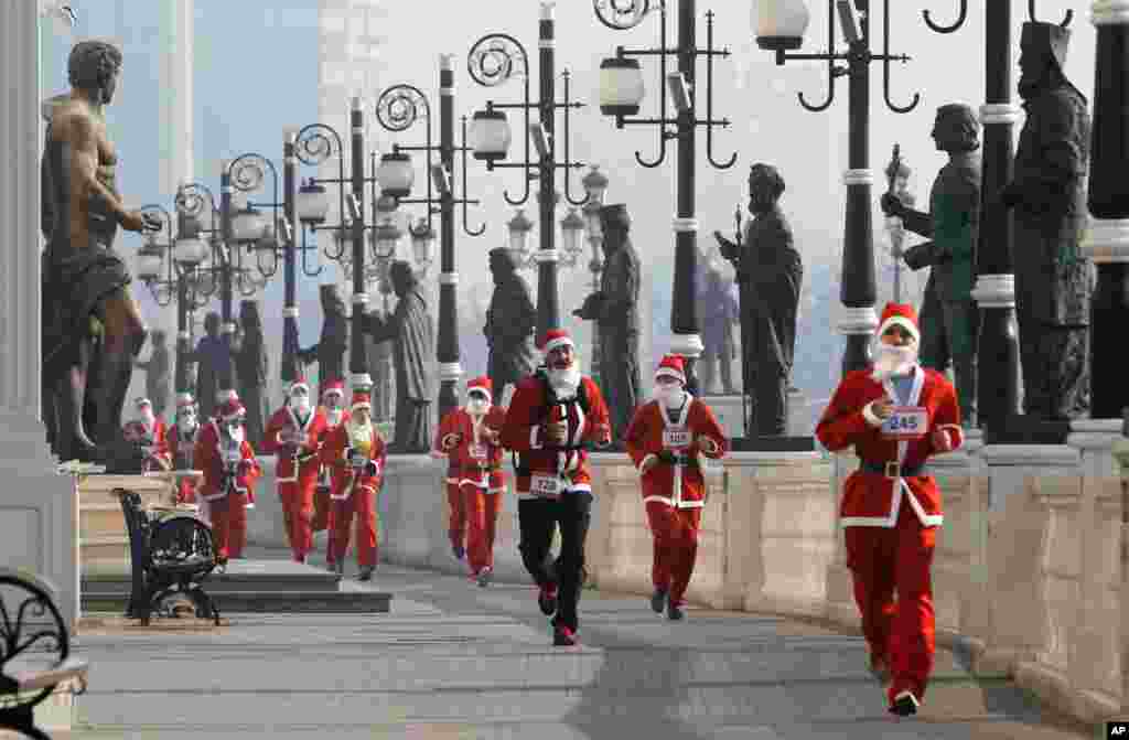 People costumed as Santa Claus run through a statue alley during a Santa Claus Race in Macedonia's capital Skopje.