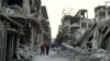 Syrian citizens walk in a destroyed street that was attacked on Wednesday by Syrian forces warplanes, at Abu al-Hol street in Homs province, Syria, Nov. 29, 2012.