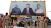 Police stand guard in front of a bill board with images of (L-R) India's Prime Minister Narendra Modi, China's President Xi Jinping and Anandiben Patel, Chief Minister of the western Indian state of Gujarat, ahead of Xi's arrival, in Ahmedabad, Sept. 16, 