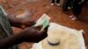 Un commerçant compte de l'argent reçu de la vente du maïs près de Lilongwe, la capitale du Malawi, le 1er février 2016. (Photo: REUTERS/Mike Hutchings)