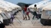 FILE - Venezuelan migrant women walk through a camp run by the U.N. refugee agency UNHCR in Maicao, Colombia, May 7, 2019. 