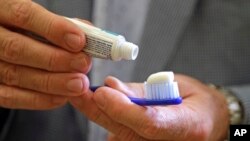 Dokter gigi Phillippe Hujoel, yang juga profesor di Universitas Washington, mengoleskan pasta gigi pada sikat giginya, di sebuah kantor di Seattle, 3 Agustus 2018.
