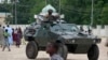 Nigerian soldiers ride on an armored personnel carrier in an area of Nigeria where an Islamic insurgency is raging, Aug. 8, 2013.