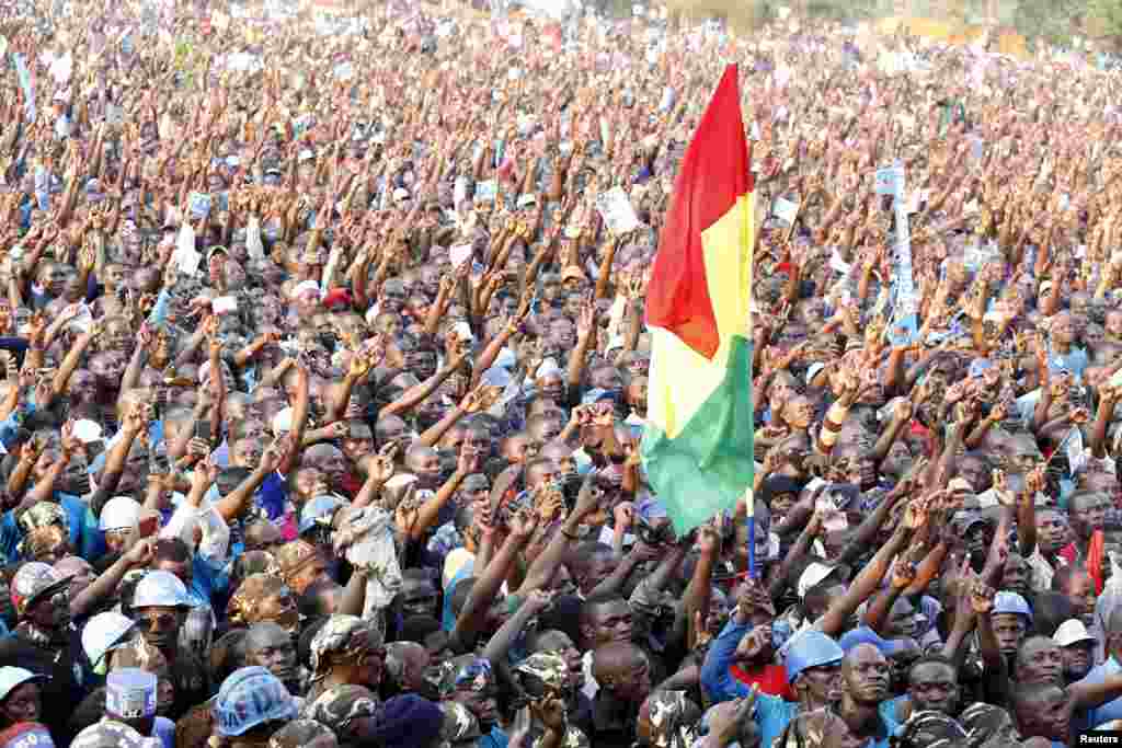 Supporters of Uganda&#39;s leading opposition presidential candidate Kizza Besigye of the Forum for Democratic Change (FDC) party hold their flag during a campaign in Jinja industrial town, in eastern Uganda.