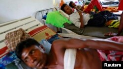 Burmese Rohingya men, who were shot by police during a riot on Friday, rest in Dapaing district clinic, outside of Sittwe, August 11, 2013.