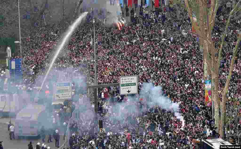Turkish riot police use tear gas and water cannons to disperse Besiktas supporters trying to pass security barriers in front of Besiktas&#39; new stadium, the Vodafone Arena in Istanbul, before the Turkish Super League soccer match between Besiktas Istanbul and Bursaspor.