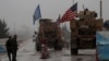 A line of US military vehicles drive through a checkpoint of the Internal Security Forces in Manbij as they head to their base on the outskirts of the northern Syrian city on December 30, 2018.