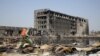 A People's Liberation Army soldier of its anti-chemical warfare corps in a protection suit sprays a liquid on debris at the site of last week's blasts in Tianjin, China, Aug. 21, 2015.