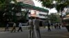 People watch a large screen displaying India's benchmark share index on the facade of the Bombay Stock Exchange (BSE) building in Mumbai, Dec. 9, 2013