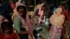FILE - Rohingya refugee women fill their canisters with water at the Leda refugee camp near Cox's Bazar, Bangladesh, Dec. 16, 2017. 
