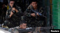 Government soldiers battling Moro National Liberation Front rebels take up positions in downtown Zamboanga city, in southern Philippines, Sept. 11, 2013. 