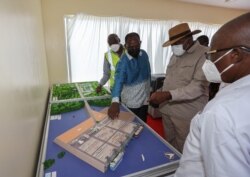 Kenya's President Uhuru Kenyatta and Kenya's Finance Minister Ukur Yatani look at the architectural model of the Chinese-funded Lamu port in Lamu, Kenya, May 20, 2021.