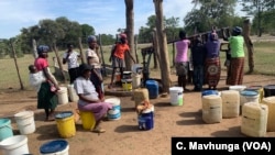 Women wait to collect water at a borehole in Zimbabwe’s Tsholotsho District, April 18, 2019.