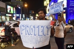 FILE - India students from various colleges hold posters as they stage a candle light vigil in support of the Tanzanian nationals who were recently assaulted by a local mob, in Bangalore on Feb. 4, 2016.