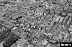 FILE - Wholesalers gather at the Tsukiji market in Tokyo, Japan, in this handout photo taken April 1, 1968, and released by Tokyo Metropolitan Government Office.