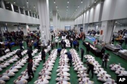 Calon pembeli memeriksa kualitas tuna sebelum lelang pertama tahun ini di Pasar Toyosu yang baru dibuka, lokasi baru pasar ikan Tokyo, 5 Januari 2019, di Tokyo.