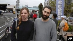 Italian Gianluca Lonati, right, and British Kayleigh Gill, both from Sydney, speak during an interview with the Associated Press at Tsukiji fish market in Tokyo, Sept. 26, 2018. They were among many tourists and locals visiting the market one recent afternoon.
