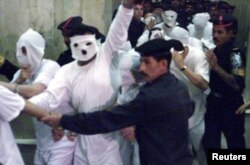 Egyptian security flank 52 men accused of sexual immorality as they arrive at a Cairo court November 14, 2001.