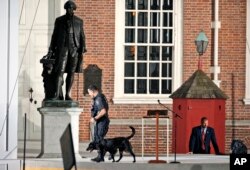 FILE - Law enforcement sweep the area in front of Independence Hall with the statue of President George Washington at left, before the arrival of Pope Francis, Sept. 26, 2015.