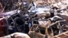 Polisi forensik berjalan melewati mobil-mobil yang hancur di dekat lokasi ledakan bom pada 12 Oktober 2002 di Kuta, Bali, 18 Oktober 2002. (Foto: Reuters)
