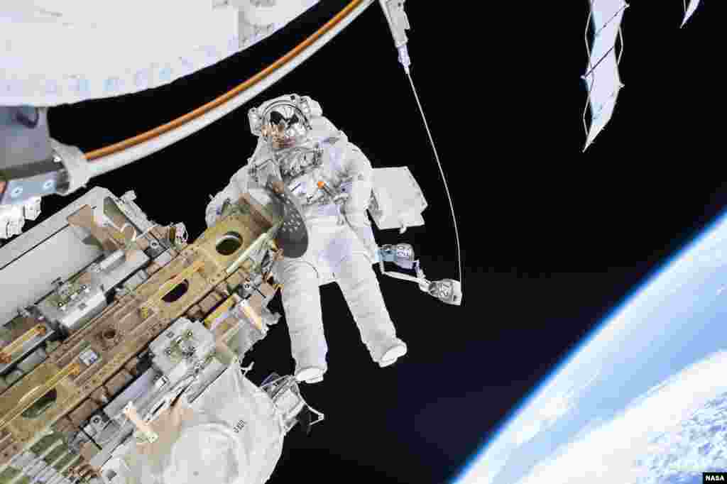 Expedition 46 Flight Engineer Tim Kopra spacewalks with Expedition 46 Commander Scott Kelly (not shown) to successfully move the International Space Station&#39;s mobile transporter rail car ahead of the docking of a Russian cargo supply spacecraft, Dec. 21, 2015.