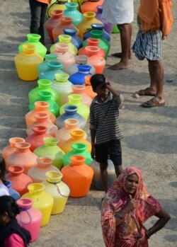 FILE - Indian residents queue with plastic containers to get drinking water from a tanker in the outskirts of Chennai, May 29, 2019. An unrelenting heat wave triggered warnings of water shortages and heatstroke in India on June 1.