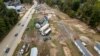 Homes and vehicles that were damaged in a flash flood from Hurricane Helene lie on the side of a road near the Swannanoa River, in Swannanoa, North Carolina, Oct. 1, 2024. 