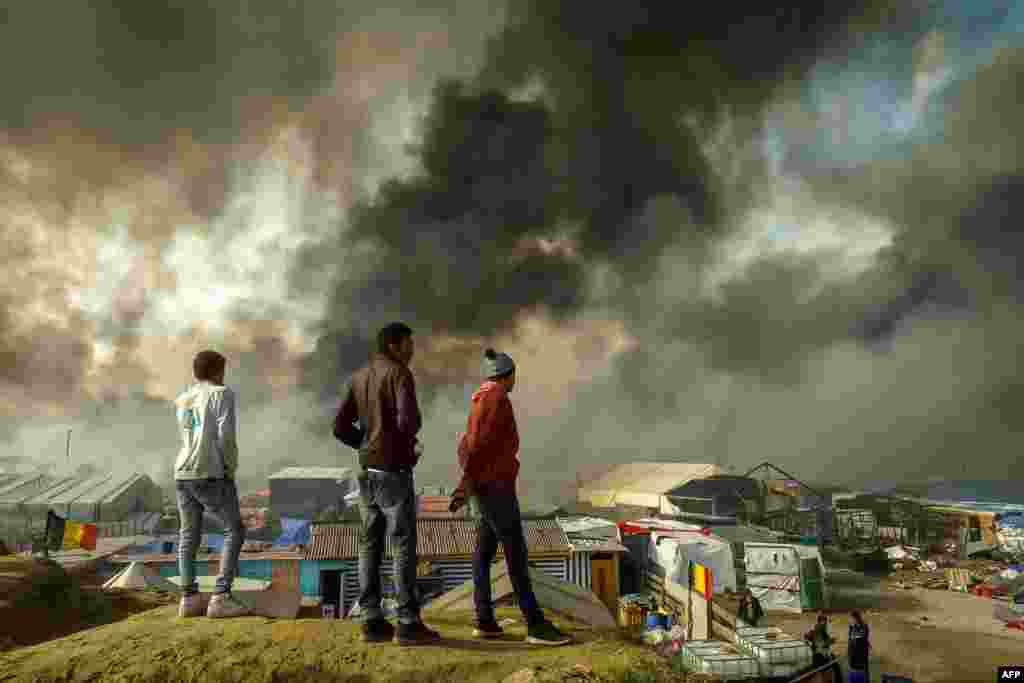 Beberapa migran di Calais, Perancis utara menonton dibongkarnya kamp pengungsi &quot;Jungle&quot; di mana 6.000-8.000 migran tinggal dalam kondisi yang memprihatinkan.