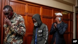 Hussein Hassan Mustafah, center, and Mohamed Ahmed Abdi, right, who were both found guilty of supporting the gunmen involved in the Westgate Mall attack in Sept. 2013, leave after the verdict is delivered at Milimani court in Nairobi, Kenya, Oct. 7, 2020.