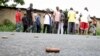 FILE - A man takes a picture of spent bullet casings lying on a street in the Nyakabiga neighborhood of Bujumbura, Burundi, Dec. 12, 2015.