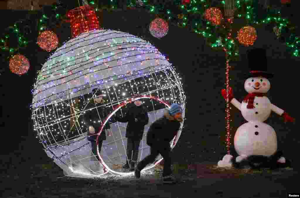 Children play in a park, which is decorated with festive lights, as a part of the New Year and Christmas holidays celebration, in Kyiv, Ukraine.