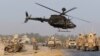 FILE - U.S. troops assess the damage to an armored vehicle of NATO-led International Security Assistance force (ISAF) at the site of a suicide attack in Jalalabad province, Aug. 24, 2014. 