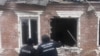 This handout photograph taken and released by the Office of the Prosecutor General of Ukraine on Feb. 6, 2024 shows law enforcement officers standing next to a house damaged as a result of a missile attack in Zolochiv, Kharkiv region.