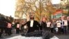 Para pengunjuk rasa membawa plakat di depan Parlemen di London, Jumat, 29 November 2024 saat anggota parlemen Inggris memberikan persetujuan awal terhadapRUU Eutanasia. (Alberto Pezzali/AP)