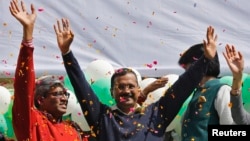 Aam Aadmi (Common Man) Party (AAP) chief and its chief ministerial candidate for Delhi, Arvind Kejriwal (C) waves to his supporters in New Delhi, February 10, 2015.