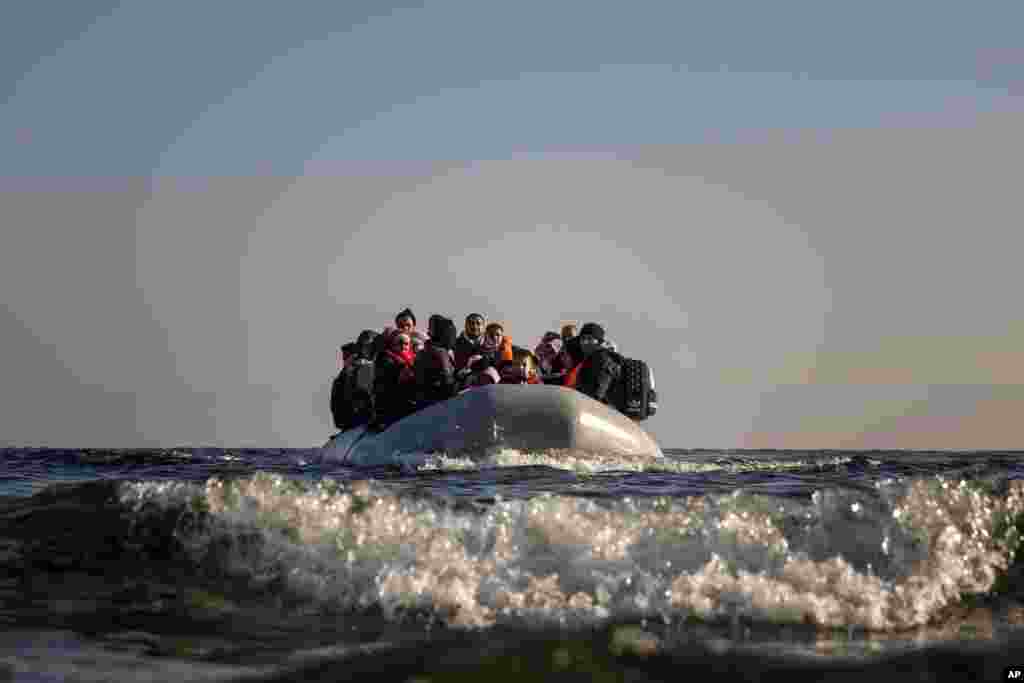 Refugees and migrants approach the Greek island of Lesbos on a dinghy after crossing the Aegean sea from the Turkish coast.