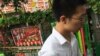 A man walks past a tricycle cart decorated with flowers and a poster with Chinese President Xi Jinping and other top leaders, parked on a street in Beijing, July 9, 2016. Overseas bar associations and lawyers groups have issued an open letter to Chinese P