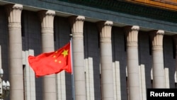 FILE- A Chinese national flag flaps in the wind outside the Great Hall of the People in Beijing.