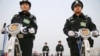 FILE - Police officers secure the area around Beijing's Great Hall of the People, March 3, 2016. Proposed changes to China's police law would give officers more discretion over using firearms. 