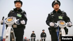 FILE - Police officers secure the area around Beijing's Great Hall of the People, March 3, 2016. Proposed changes to China's police law would give officers more discretion over using firearms. 
